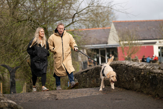 Woman wearing the Wild & Free COBE waterproof coat on a dog walk in autumn, UK and Ireland